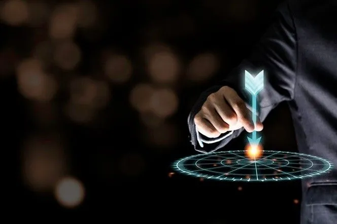 A person in a suit pointing at a digital interface with a glowing arrow and circular grid, suggesting a futuristic or tech-focused concept.